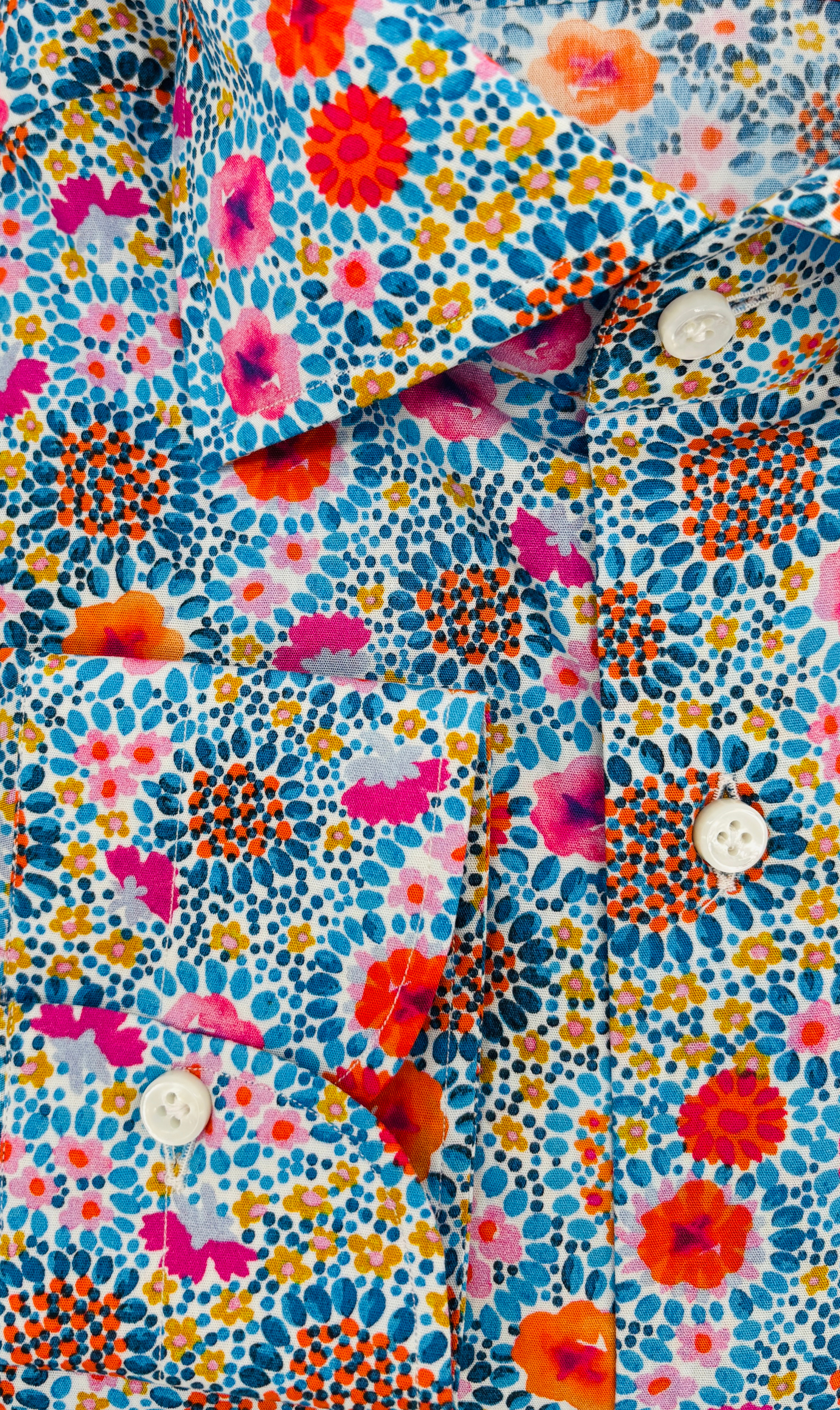 Manschetten und Perlmuttknöpfe des Slim-Fit-Hemds mit blauen bunten blumen-Muster, gefertigt aus ägyptischer Baumwolle in Italien.