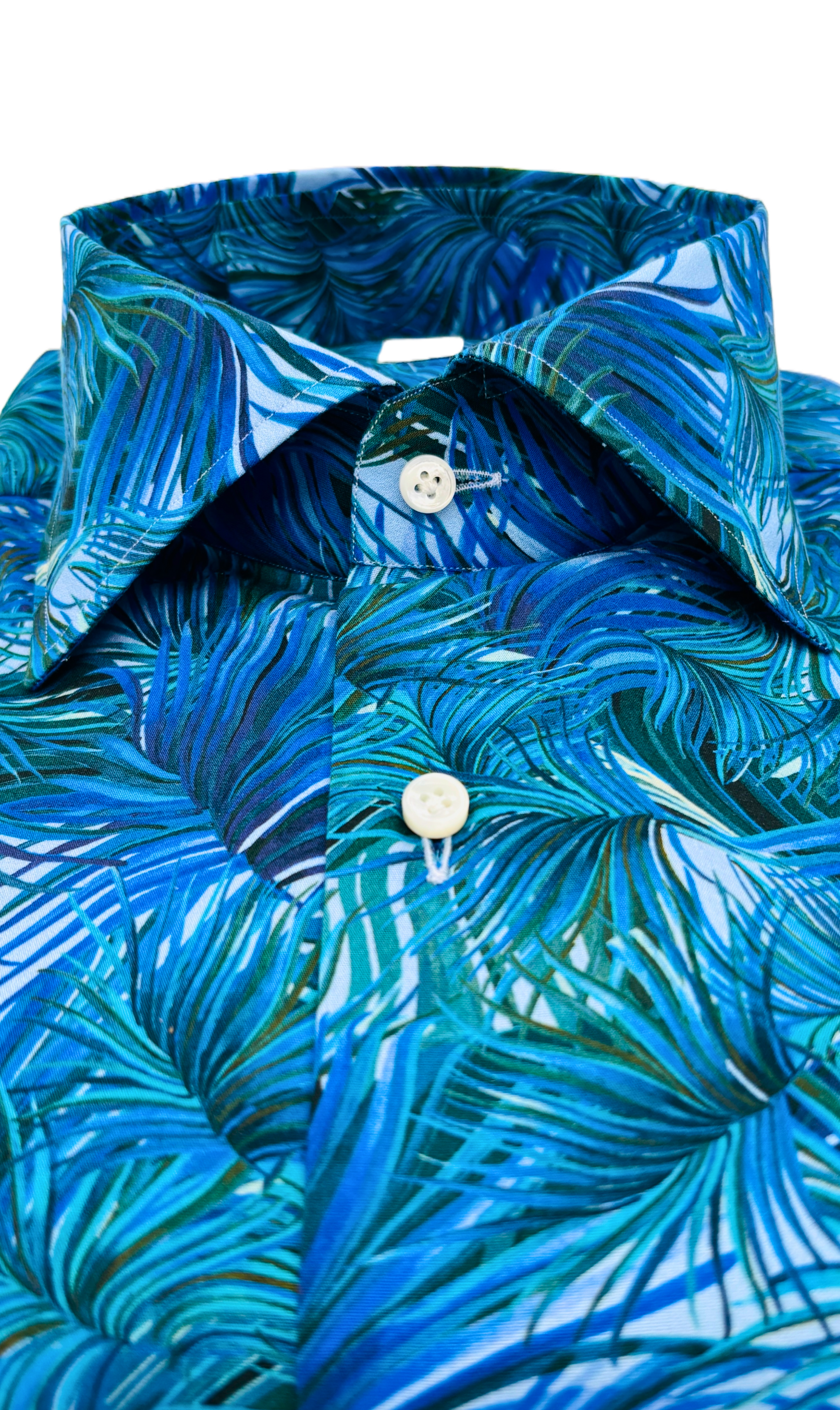 Detailansicht des Softcollar-Kragens und der runden Manschetten des nachhaltigen Herrenhemds mit blauen Palmen-Muster.